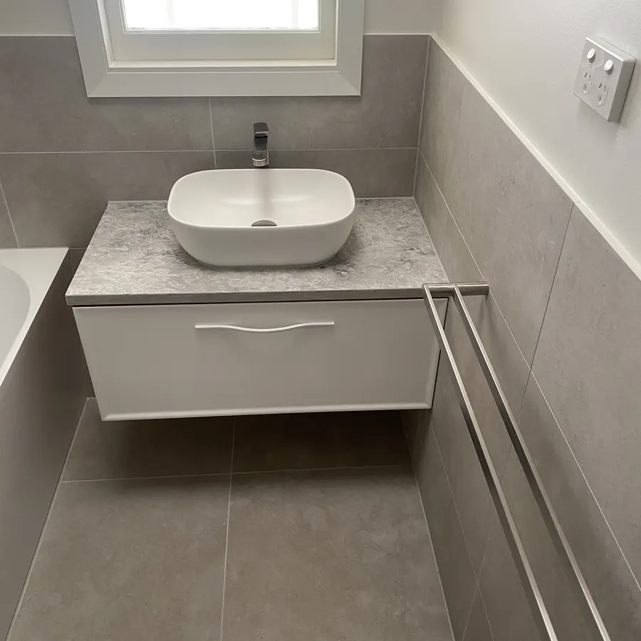 Compact renovated utility space with a wall-hung vanity and storage