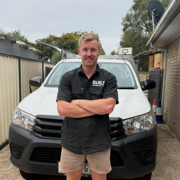 Built Carpentry owner Jordan in front of the work vehicle