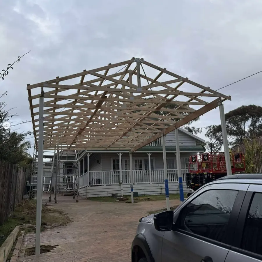 Timber carport roof framing set out on steel posts
