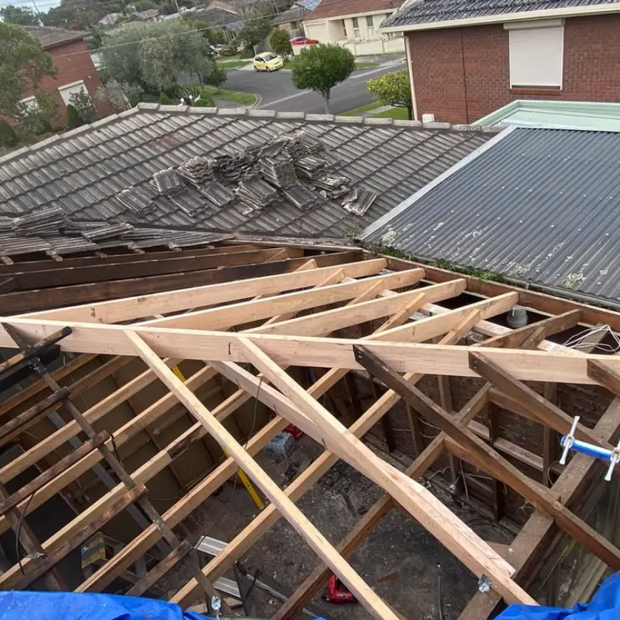 Damaged roof stripped of tiles with new structural framing installed