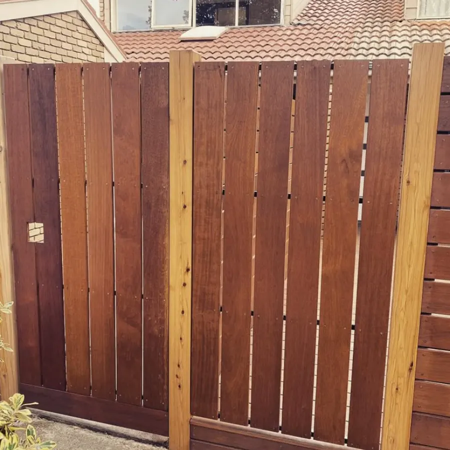 Two timber gates set between horizontal slat fencing