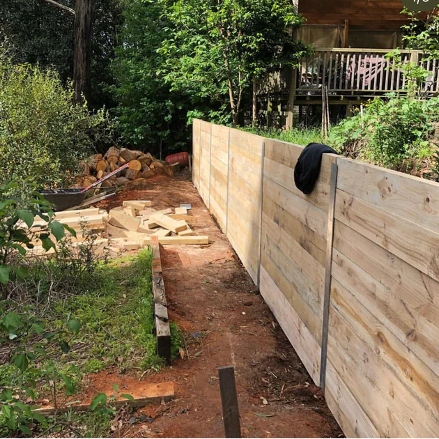 Timber retaining wall construction in progress